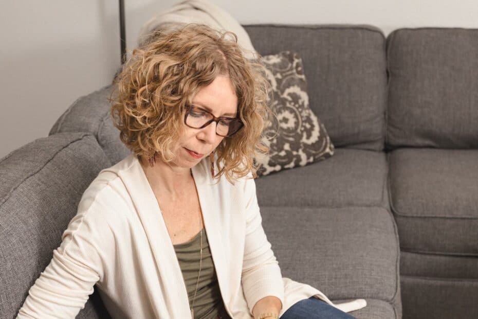 Woman sitting on couch writing