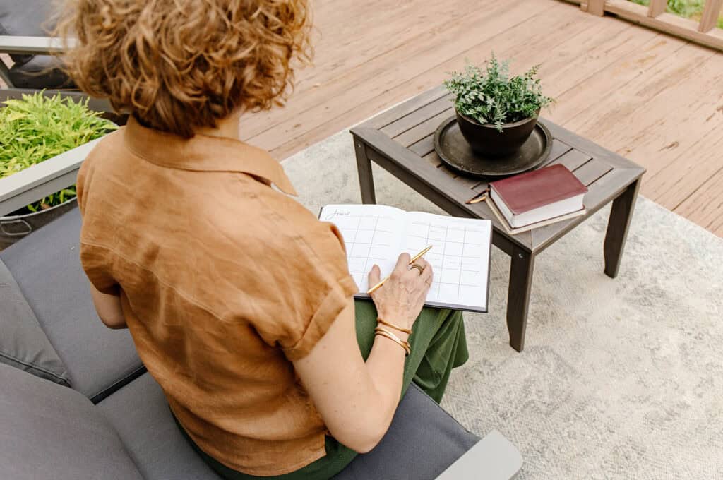 Lady sitting on a couch with a planner, ready to practice implementation intentional.