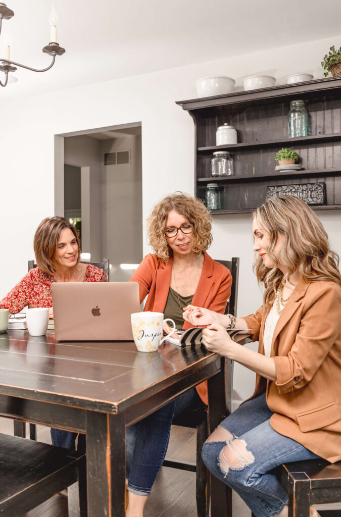 Time management coaching session for Christian women gathered around a table with laptops and coffee