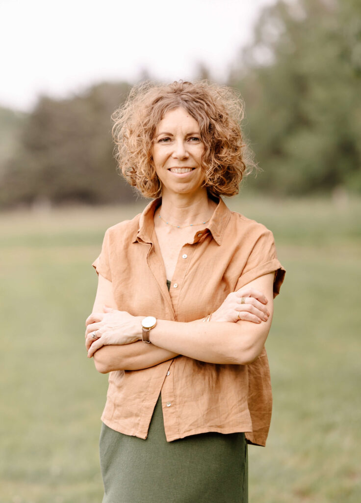 Lissa, founder of Redeem Her Time, standing outdoors with arms crossed